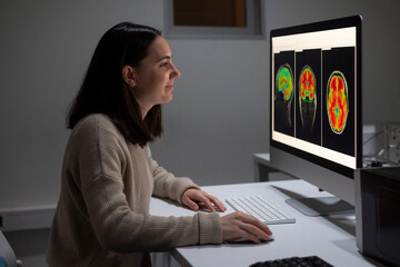 Female analyzing brain scan on computer