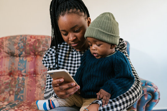 Black Mom With Baby Using Cellphone