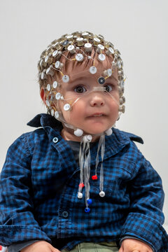 Portrait of a toddler in EEG cap in a lab