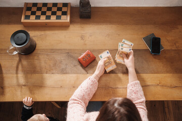 Anonymous Woman With Child Counting Euro Bills 