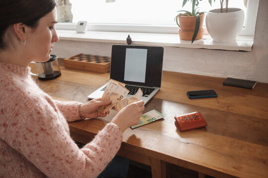 Woman Sitting At The Desk And Counting Money