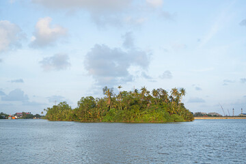 Small island in the middle of a river with clouds in the background