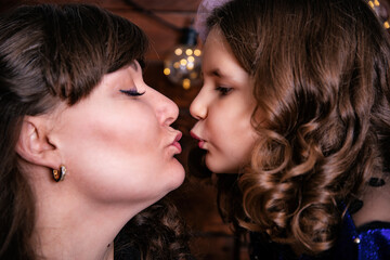 A cute little girl kisses her mom.