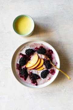 Quinoa breakfast porridge with blackberries and peach
