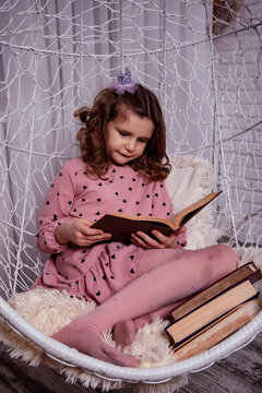Portrait of a little girl reading a book. Reading literature outside the classroom.