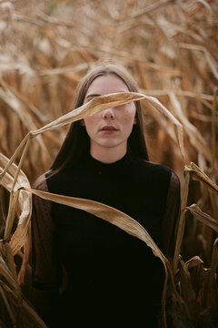 Young woman in dry corn field
