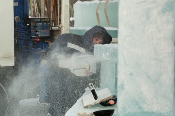 Worker cuts ice panel with gasoline saw