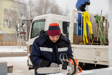 Fototapeta premium Portrait of an assembler with a chainsaw in his hands