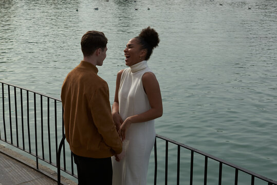 Couple holding hands next to a lake park