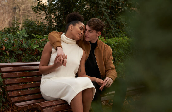 Portrait of a multiracial couple at a bench park
