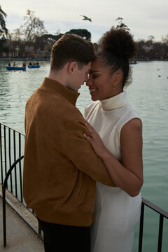 Couple hugging next to a lake park