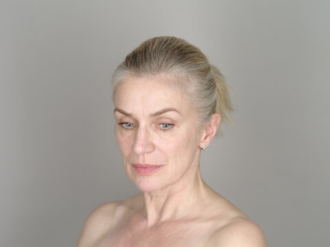 Thoughtful adult model on gray