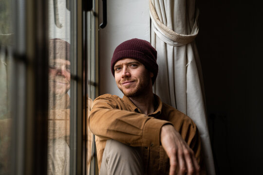 Portrait of smiley man sitting by the window at home