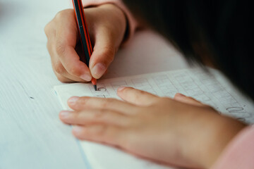 Child girl writing math numbers