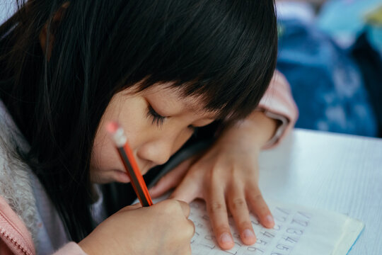 Child girl writing math numbers