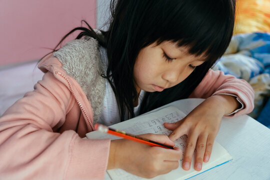 Child girl writing math numbers