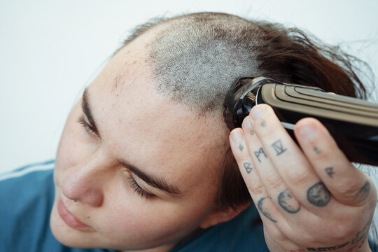 Young non binary person with shaved hair