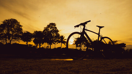 bike parked in the meadow in the evening. bicycle silhouette