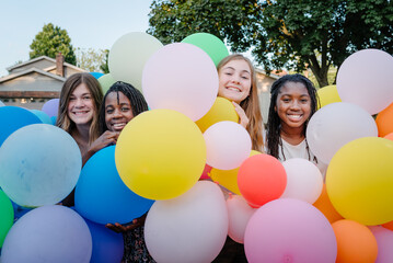 Smiling diverse friends with balloons
