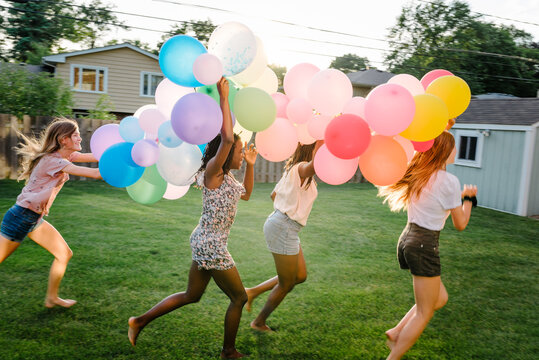 Silly diverse girls with balloons