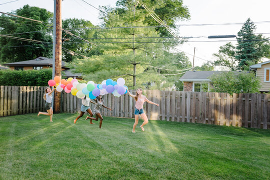 Diverse girls running with balloons
