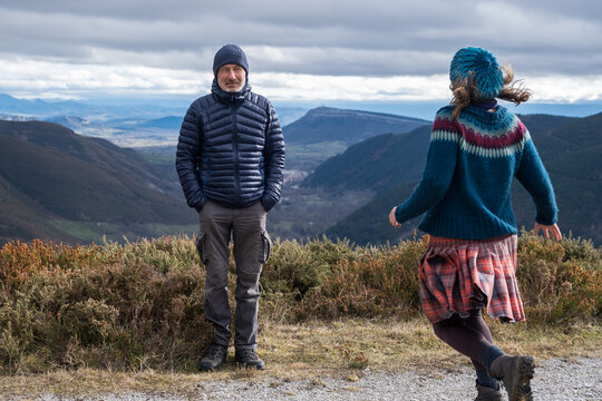 woman runs towards man who's hands are in his pockets