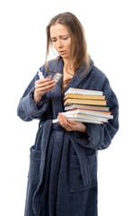 A woman in a bathrobe holds a lot of books and medicine. a person is treated. Drinking a lot and staying at home. relaxes with an interesting book. sick leave. coronavirus, flu, epidemic. isolated.
