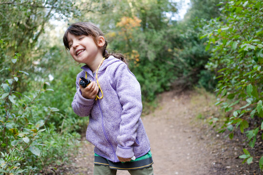 Little girl playing with walkie talkies outdoors