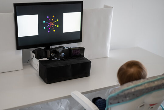 Kid sitting at table with computer monitoring gaze