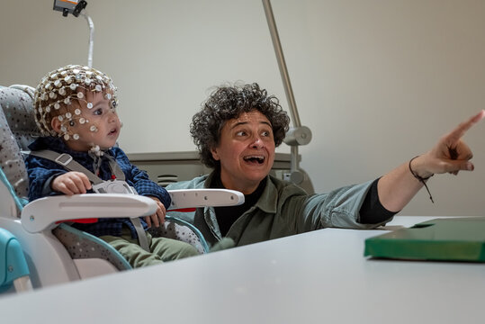 Researcher making neural study on kid in EEG cap