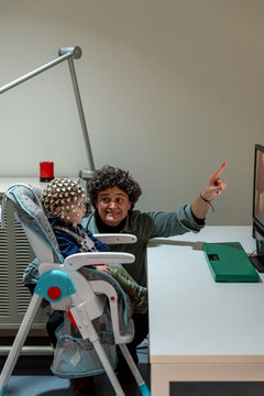 Researcher making neural study on kid in EEG cap