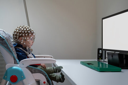 Baby Boy in EEG cap looking at monitor in laboratory