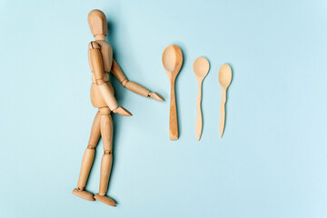 Wooden objects with a wooden mannequin on a blue background. Zero waste concept. Eco friendly reusable items. Copy Space