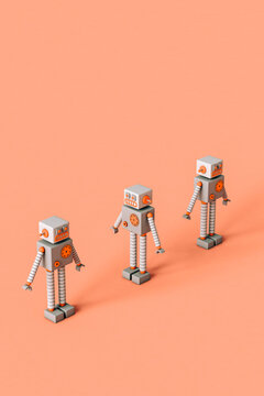 three Toy robots on a pink background