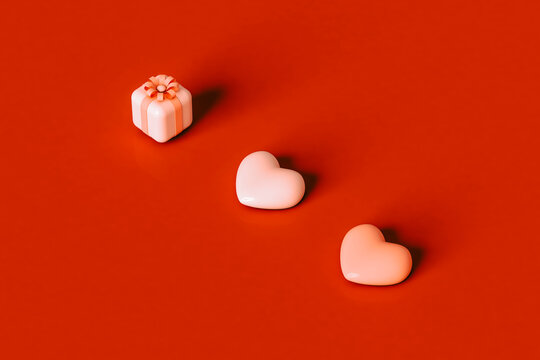  three 3D hearts and pink presents on red background.