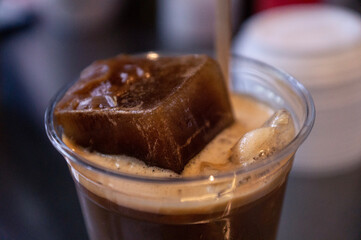 Ice cube of coffee in coffee