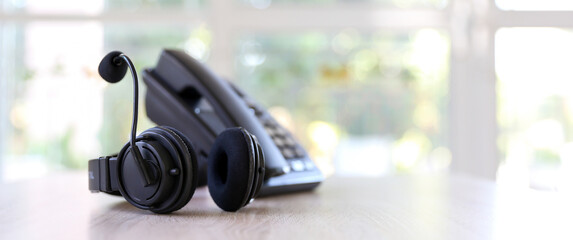 Customer service concept. Close-up headphone and telephone for communication helpdesk IT support or call center and online services.