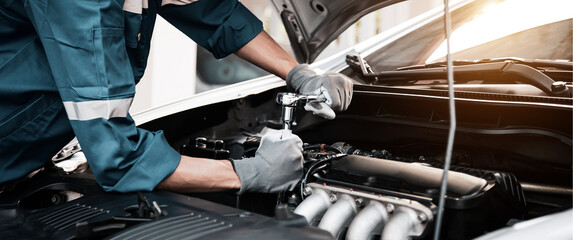 Car care maintenance and servicing, Close-up hand technician auto mechanic using the wrench to...