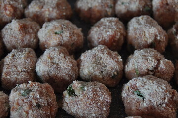 Fototapeta na wymiar Meatballs with parsley and in breadcrumbs and tomato sauce with spices. Delicious meat dinner dish for potatoes and salads.