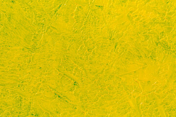 abstract bright colored background: yellow paint on blue fabric close