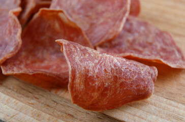 Meat chips lie on a wooden surface.