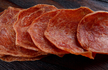 Meat chips are laid out in a row. Thin pieces of dried meat.