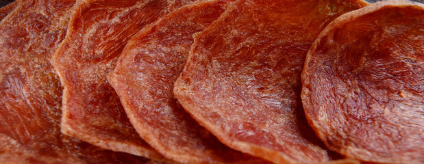 Meat chips are laid out in a row. Thin pieces of dried meat.