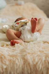 a newborn baby in a diaper lies on the bed.
