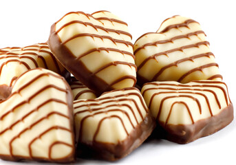 A bunch of heart - shaped chocolates on a white background .