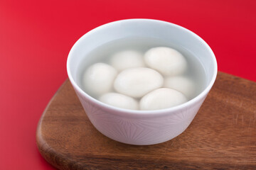 A bowl of cooked dumplings on a cutting board