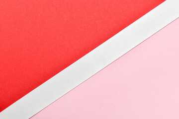 The pink and red background is divided in half diagonally by a white ribbon