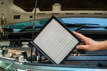 The new car air filter has a handle placed on the front of the car with the engine cover open.