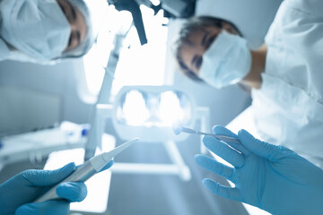 Dentist and assistant at work. Patient's point of view	