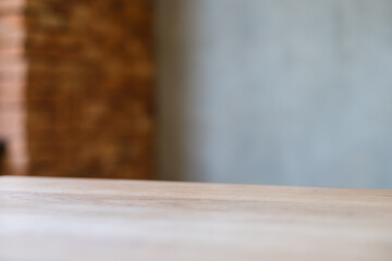 Wooden table top with blurred of concrete wall background